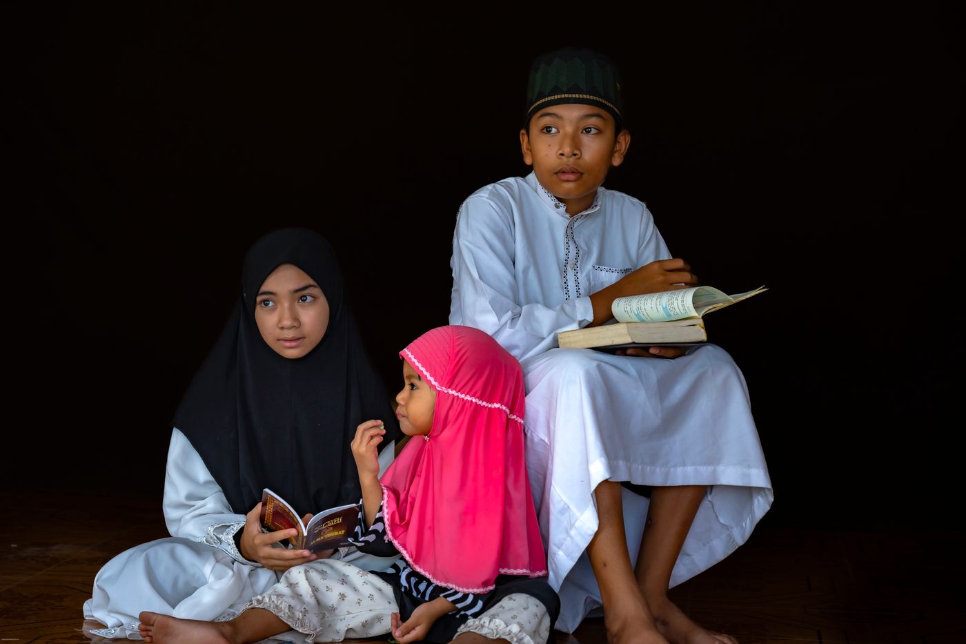 Children reading together with focus and concentration at a community madrasa