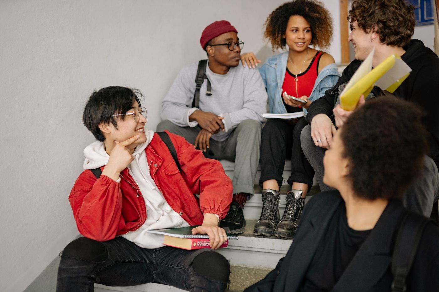 A diverse group of young people collaborating and smiling together indoors